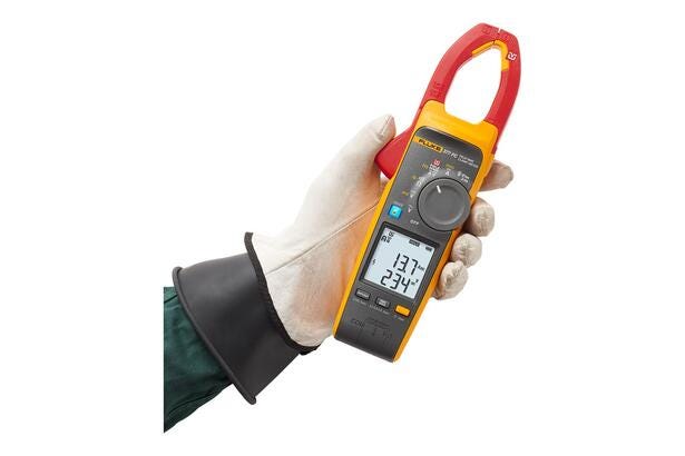 Tekniker med isolerende handske holder et Fluke 377 FC tangamperemeter til måling af strøm.