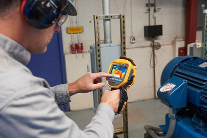 Tekniker anvender Fluke Ti401 PRO termisk kamera til temperaturmåling af industriel elmotor.
