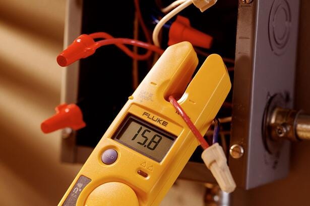 Fluke T5-1000 elektrisk tester måler strøm med åben strømklo på en rød ledning.
