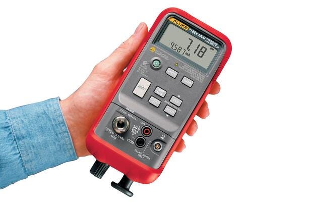 Trykkalibrator Fluke 718Ex 30G holdes i hånden med digital visning af tryk og strøm.