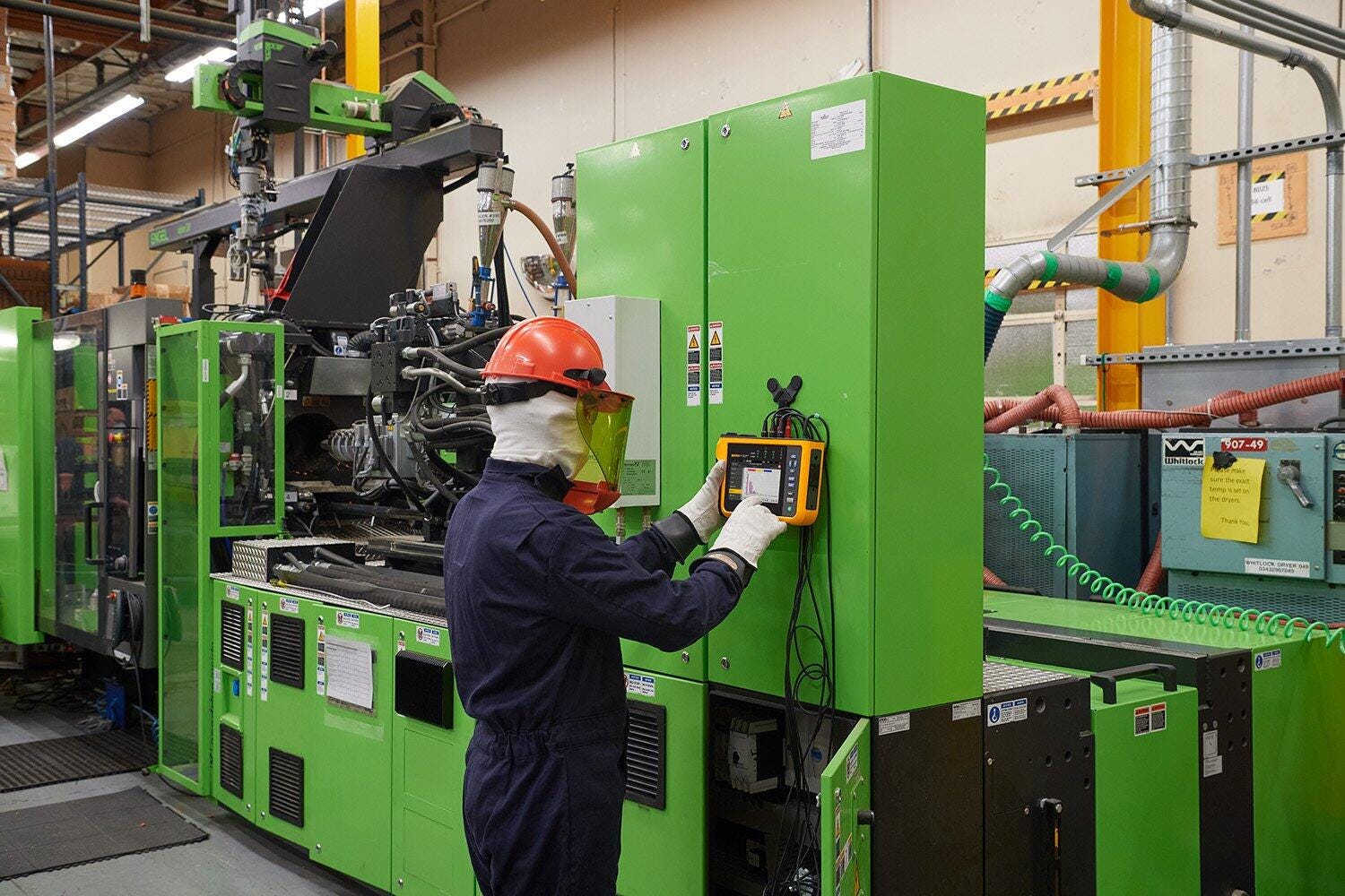 Tekniker i beskyttelsesudstyr anvender Fluke 1775 Power Quality Analysator på et industrielt elpanel.