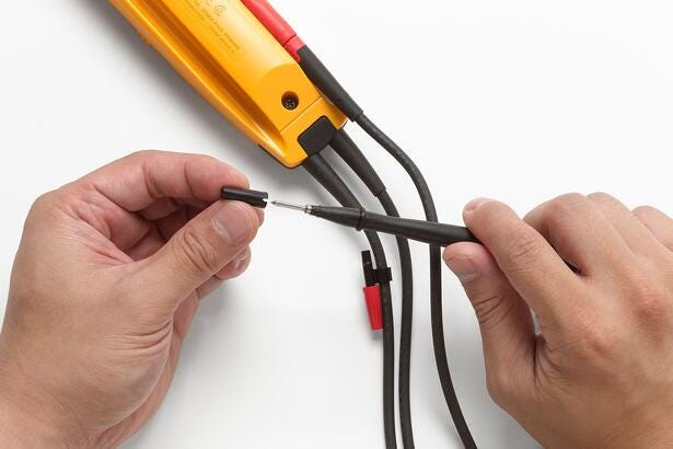 Nærbillede af hænder der monterer SlimReach testprober på en Fluke T5-1000 elektrisk tester.