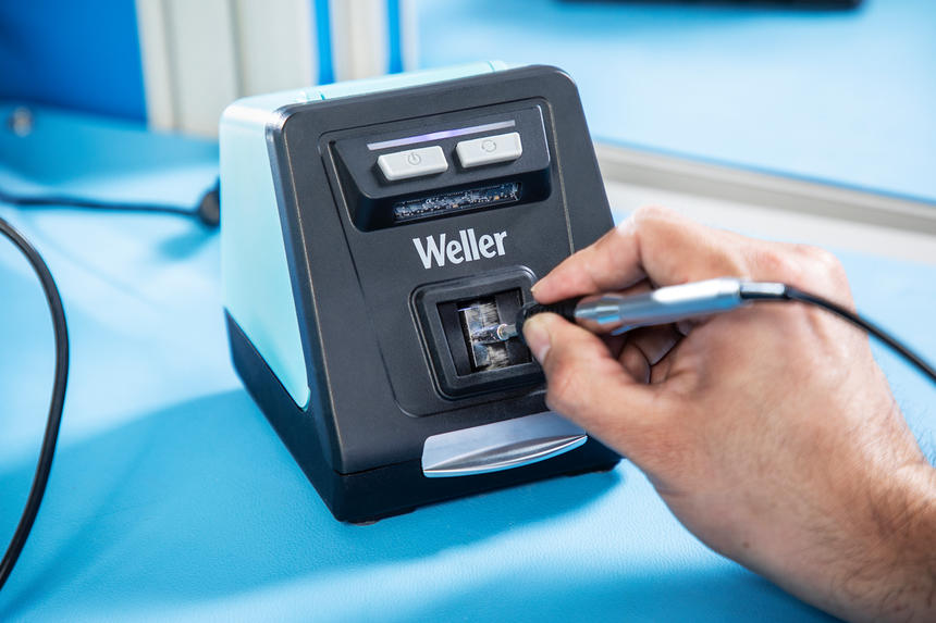 Nærbillede af hånd der rengør loddespids med Weller automatisk tip-renser